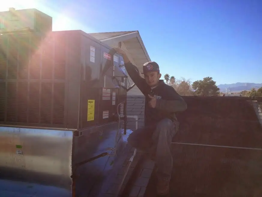 HVAC technician performing Heat Pump Repair on a rooftop unit in Fort Mitchell